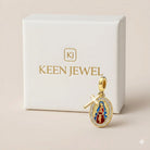 Gold pendant with religious design on a Keen Jewel branded box